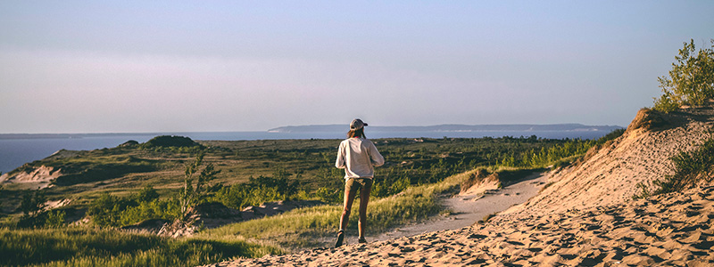 Woman Hiking Michigan Sand Dunes | Michigan Travel Club